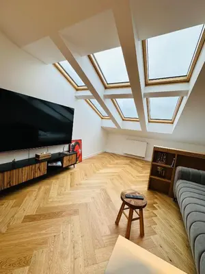 a living room with skylights and a large flat screen tv at Sky Studio Old Town in Kraków