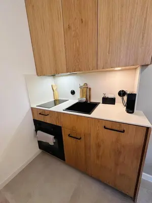 a kitchen with a sink and wooden cabinets at Sky Studio Old Town in Kraków