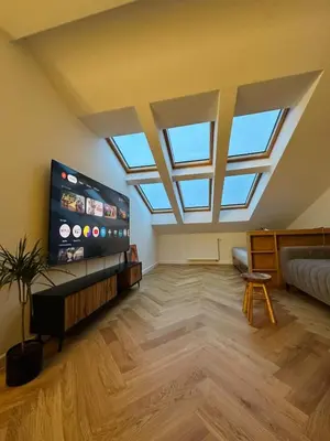 a large living room with a skylight and a tv at Sky Studio Old Town in Kraków