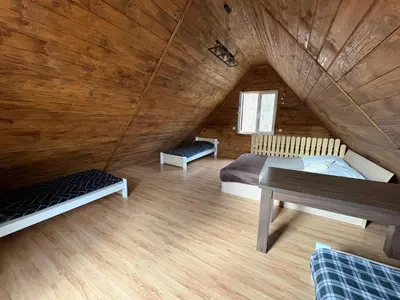 a living room with a couch and a kitchen with a table at Zacisze z Balia in Łostówka
