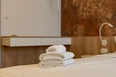 a pile of towels sitting on top of a bed at Zabłocie Harmony Apartment by BookingHost in Kraków