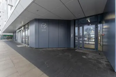 an empty hallway of an office building with glass doors at Zabłocie Harmony Apartment by BookingHost in Kraków