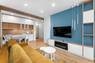 a living room with a couch and a large tv at Zabłocie Harmony Apartment by BookingHost in Kraków