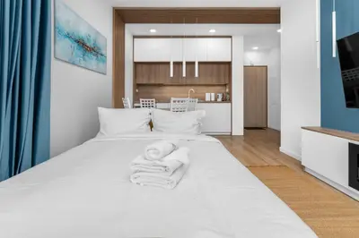 a baby laying on a bed in a bedroom at Zabłocie Harmony Apartment by BookingHost in Kraków
