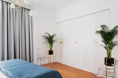 a bedroom with white cabinets and two potted plants at QUEEN #2 APARTMENT, WAWEL VIEW, OLD TOWN, Kraków in Kraków