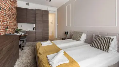 a bedroom with two beds and a desk in it at Rakowicka Residence, Sun & Snow in Kraków