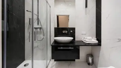 a black and white bathroom with a sink and a shower at Rakowicka Residence, Sun & Snow in Kraków