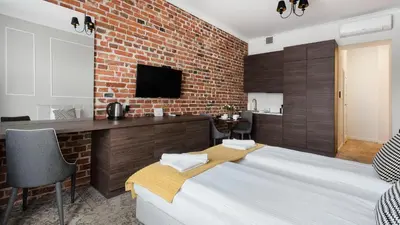 a bedroom with a bed and a brick wall at Rakowicka Residence, Sun & Snow in Kraków