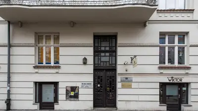 a white building with black doors and windows at Rakowicka Residence, Sun & Snow in Kraków