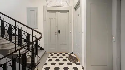 a hallway with a white door and a checkered floor at Rakowicka Residence, Sun & Snow in Kraków