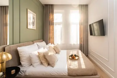 a white bed with a bowl of oranges on it at Perfect Apartment in the Old Town 5min Market Square AC WiFi Parking in Kraków