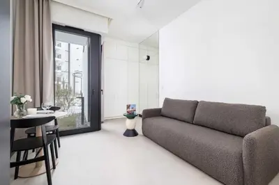 a living room with a couch and a table at Stylish Apartment with Underground Parking Located Near the TAURON Arena by Noclegi Renters in Kraków