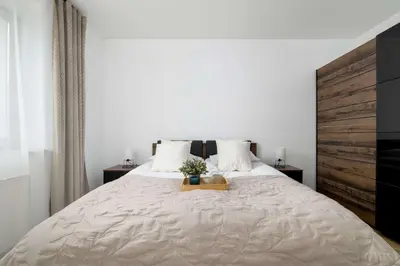 a bedroom with a large bed with a wooden headboard at Bright One-Bedroom Apartment Functional Interiors Remote Working by Noclegi Renters in Kraków