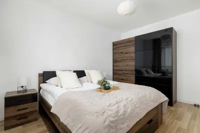 a bedroom with a large bed with a wooden headboard at Bright One-Bedroom Apartment Functional Interiors Remote Working by Noclegi Renters in Kraków