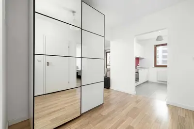 a large glass partition in a living room with a kitchen at Bright One-Bedroom Apartment Functional Interiors Remote Working by Noclegi Renters in Kraków