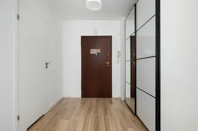 a hallway with a wooden door and a mirror at Bright One-Bedroom Apartment Functional Interiors Remote Working by Noclegi Renters in Kraków