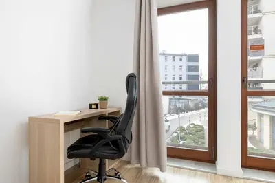 a desk with a chair in front of a window at Bright One-Bedroom Apartment Functional Interiors Remote Working by Noclegi Renters in Kraków