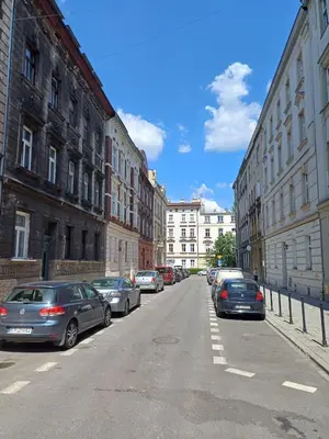 a street with cars parked on the side of the road at city center 2 rooms 1 kitchen in Kraków