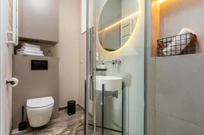 a bathroom with a toilet and a sink and a shower at Old Town 5min Main Market Square Perfect Apartment AC WiFi Parking Balcony in Kraków