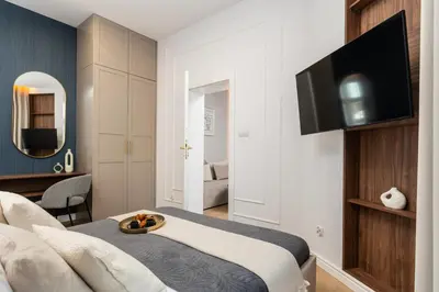 a kitchen with white cabinets and a table with flowers at Old Town 5min Main Market Square Perfect Apartment AC WiFi Parking Balcony in Kraków