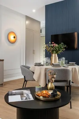 a dining room table with a vase of flowers on it at Old Town 5min Main Market Square Perfect Apartment AC WiFi Parking Balcony in Kraków