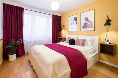 a bedroom with a large bed with red curtains at Tomasza 25 Apartment 2 in Kraków