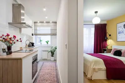 a small bedroom with a bed and a kitchen at Tomasza 25 Apartment 2 in Kraków
