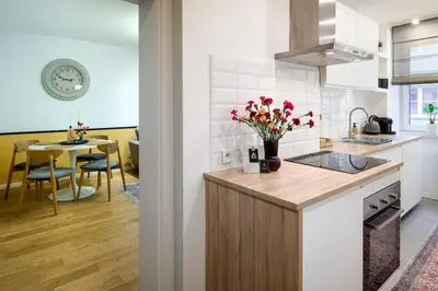 a kitchen with a counter and a table with flowers at Tomasza 25 Apartment 2 in Kraków