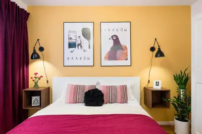 a bedroom with a pink bed with pictures on the wall at Tomasza 25 Apartment 2 in Kraków