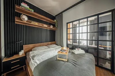 a bedroom with a bed and a table with a drink on it at Grzegórzki Apt - Air Con, Balcony, Vistula View - by Rentujemy in Kraków