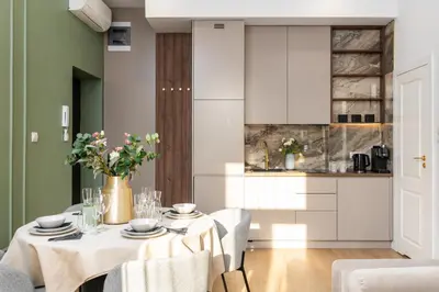 a kitchen with white cabinets and a table with flowers at 2x Perfect Apartment OLD TOWN 5min Main Market Square AC WiFi Parking Balcony in Kraków