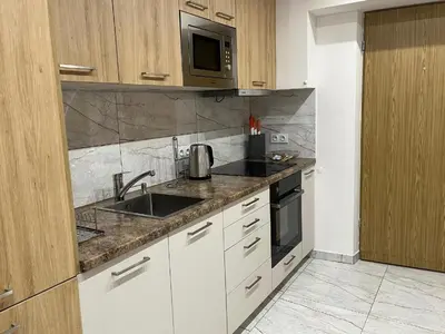 a kitchen with a sink and a microwave at Saint Cross Apartment in Kraków
