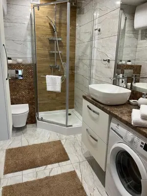 a bathroom with a sink and a washing machine at Saint Cross Apartment in Kraków