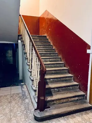 a staircase in a house with a red wall at Saint Cross Apartment in Kraków