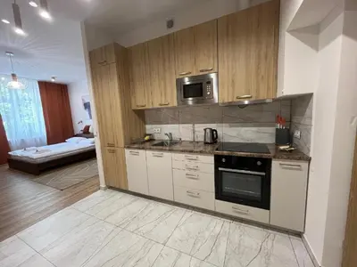 a kitchen with a stove and a microwave at Saint Cross Apartment in Kraków