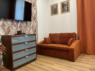 a living room with a couch and a flat screen tv at Saint Cross Apartment in Kraków