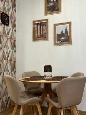 a table with chairs and a wine glass on top at Saint Cross Apartment in Kraków