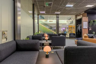 a waiting room with couches and tables and chairs at Vistula Lounge - Night Access - Kraków Główny in Kraków