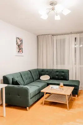 a green couch in a living room with a table at Łagiewniki Apt - 52 m2, Workspace - by Rentujemy in Kraków