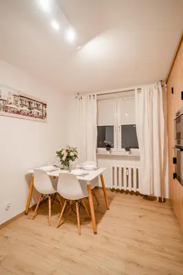 a white dining room with a table and chairs at Łagiewniki Apt - 52 m2, Workspace - by Rentujemy in Kraków