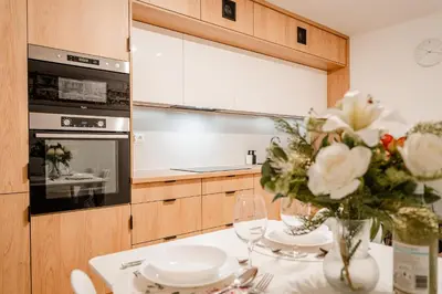 a kitchen with a table with a vase of flowers at Łagiewniki Apt - 52 m2, Workspace - by Rentujemy in Kraków