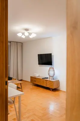 a living room with a television and a wooden floor at Łagiewniki Apt - 52 m2, Workspace - by Rentujemy in Kraków