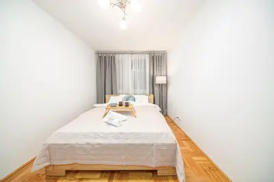 a white bedroom with a large bed and a window at Łagiewniki Apt - 52 m2, Workspace - by Rentujemy in Kraków