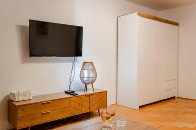 a living room with a tv on a white wall at Łagiewniki Apt - 52 m2, Workspace - by Rentujemy in Kraków