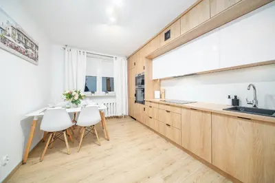 a kitchen with a table and two white chairs at Łagiewniki Apt - 52 m2, Workspace - by Rentujemy in Kraków