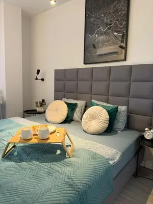 a bedroom with a bed with a table on it at Golden Honey Apartment- Studio Cracow Old Town in Kraków