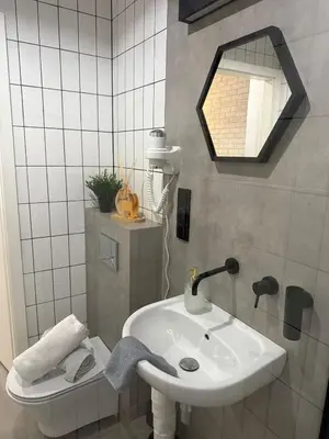 a bathroom with a white sink and a mirror at Golden Honey Apartment- Studio Cracow Old Town in Kraków