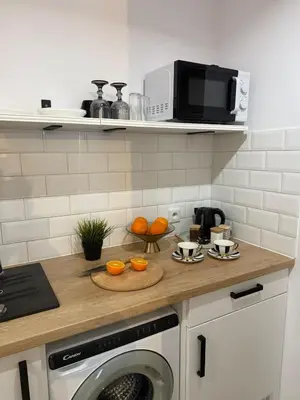 a kitchen with a counter top with a microwave and oranges at Golden Honey Apartment- Studio Cracow Old Town in Kraków