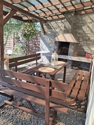 a picnic table and bench in front of a stone oven at Domek u Gosi