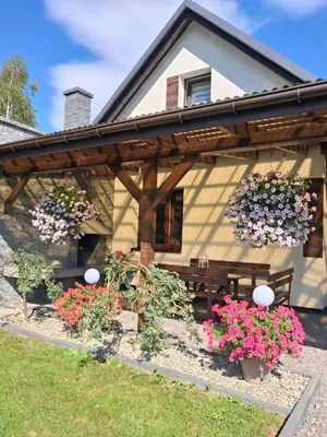 a house with flowers in front of it at Domek u Gosi